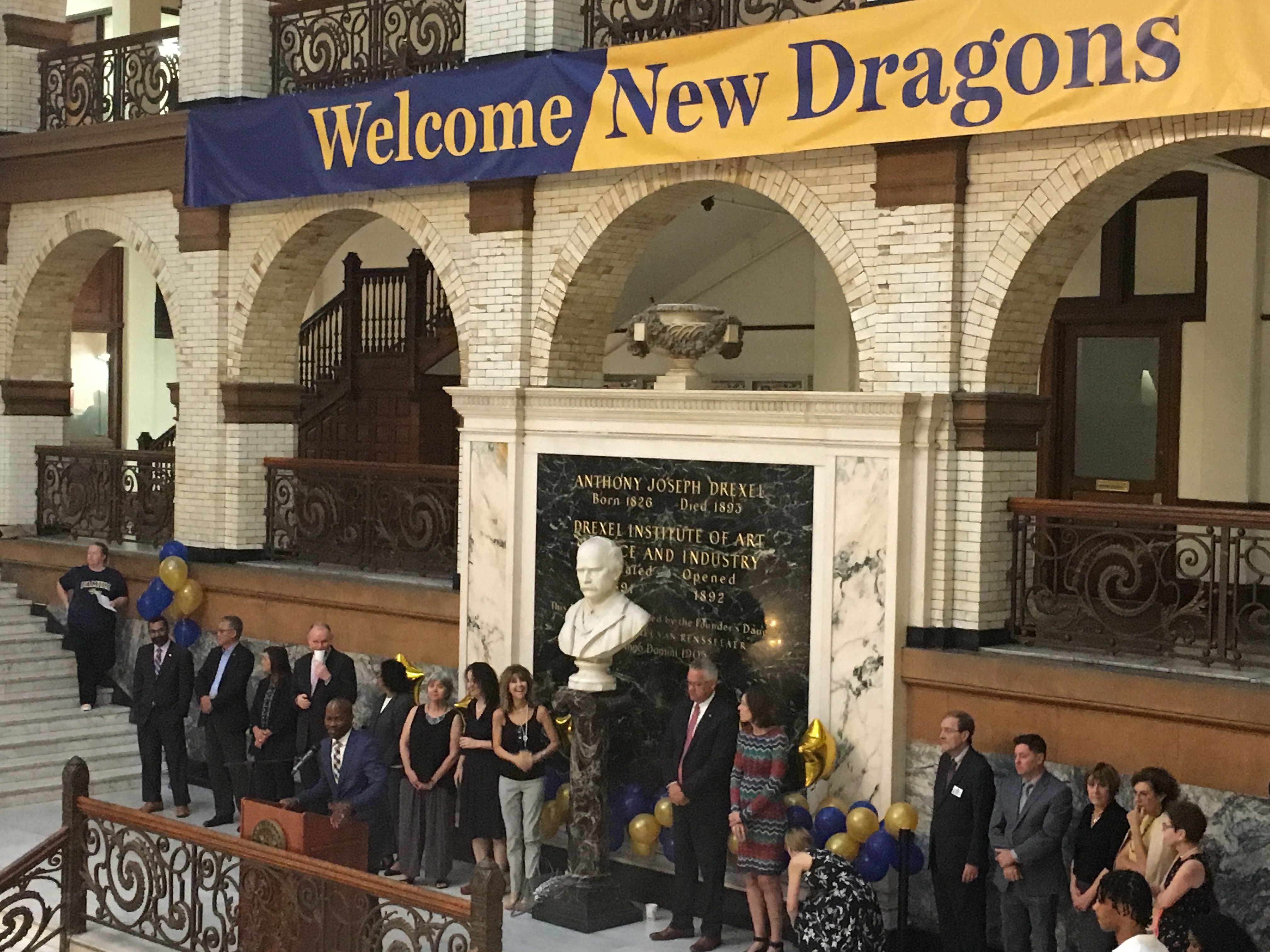 Drexel Deans stand in a row in front of a bust of AJ Drexel